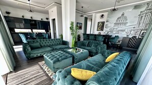 A modern living room with a sectional sofa, a coffee table, and a dining area. - Hotel Del Medio (Sutomore)