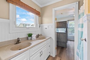 Une salle de bain avec deux lavabos, un miroir et une fenêtre.