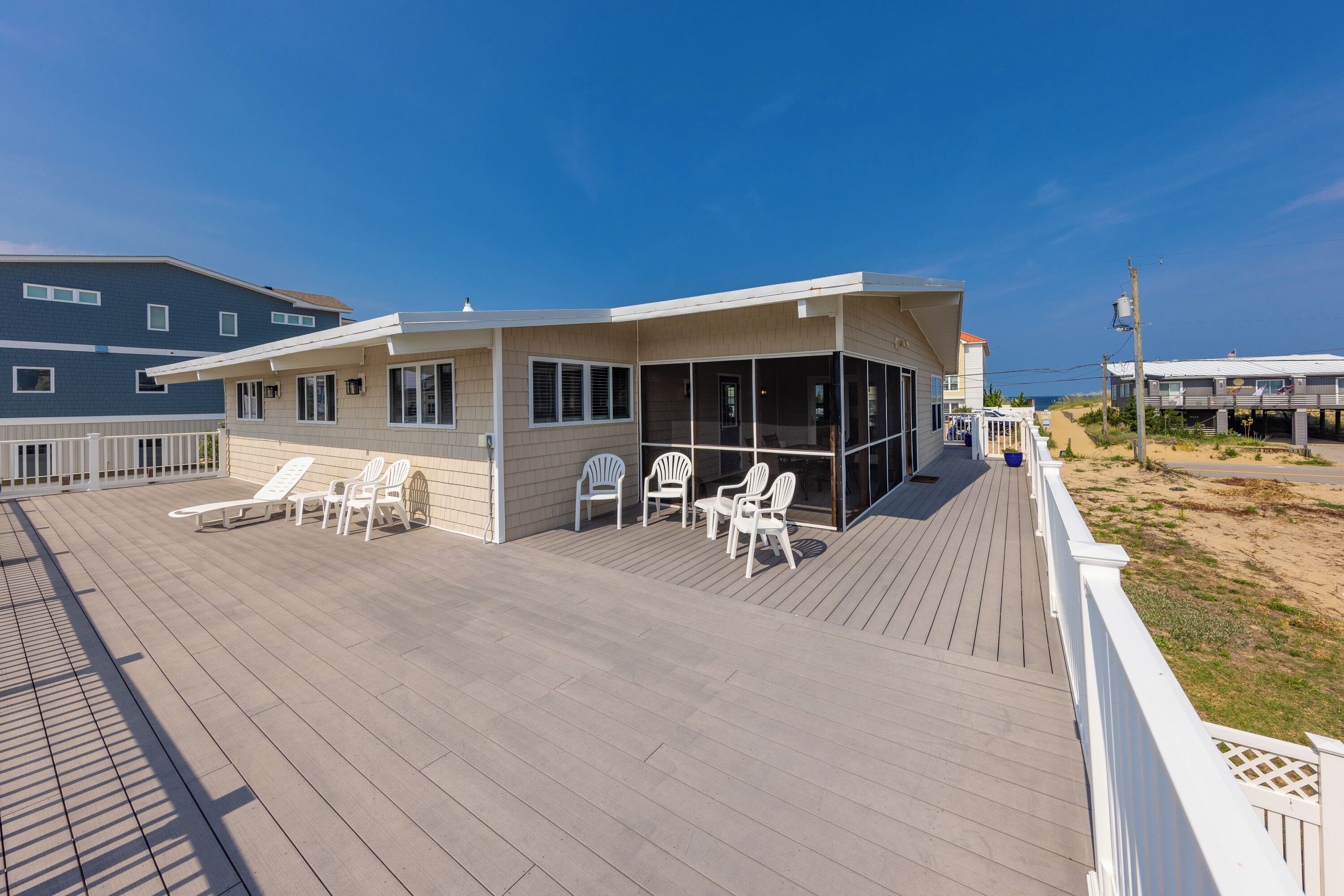 A beachfront property with a covered patio area, outdoor seating, and a view of the ocean.
