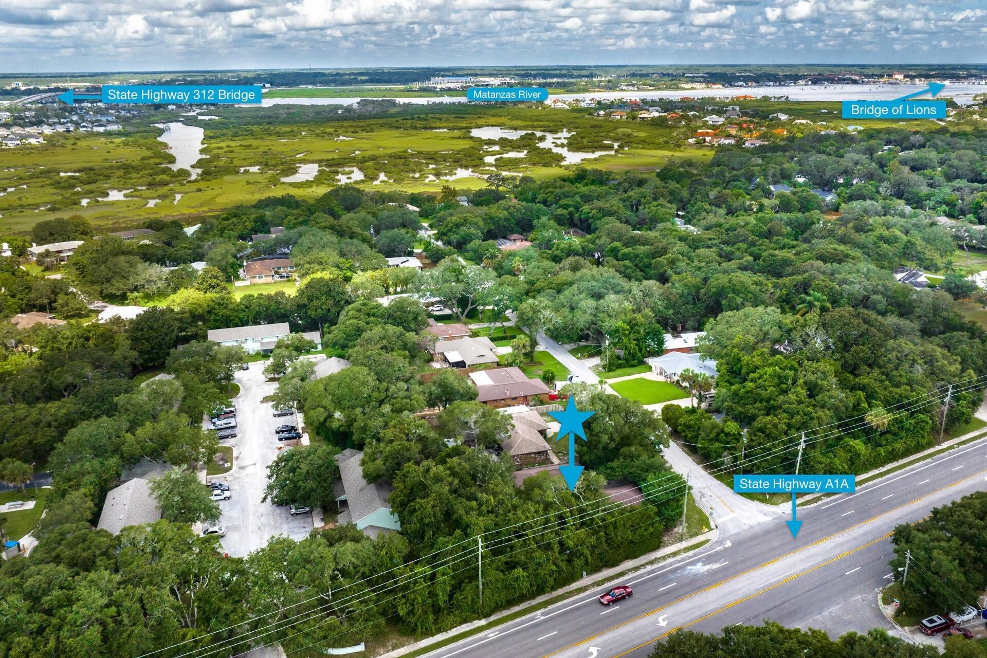 Vue aérienne d’un quartier résidentiel avec des maisons, des routes et un pont.