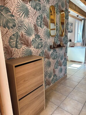 Relax in a serene space with a large mirror, wooden cabinet, and comfortable seating area.
