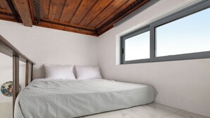 A bedroom with a bed, a window, and a wooden ceiling. - Casa Traditionale (Rhodes)