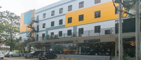 Un hotel de varios pisos con un acceso cubierto y una escalera contra incendios.