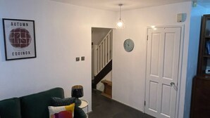 Una sala de estar con un sofá verde, una mesa de centro y un cuadro en la pared.
