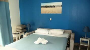 Une chambre d’hôtel avec un lit, une table de chevet, une lampe et un tableau accroché au mur.