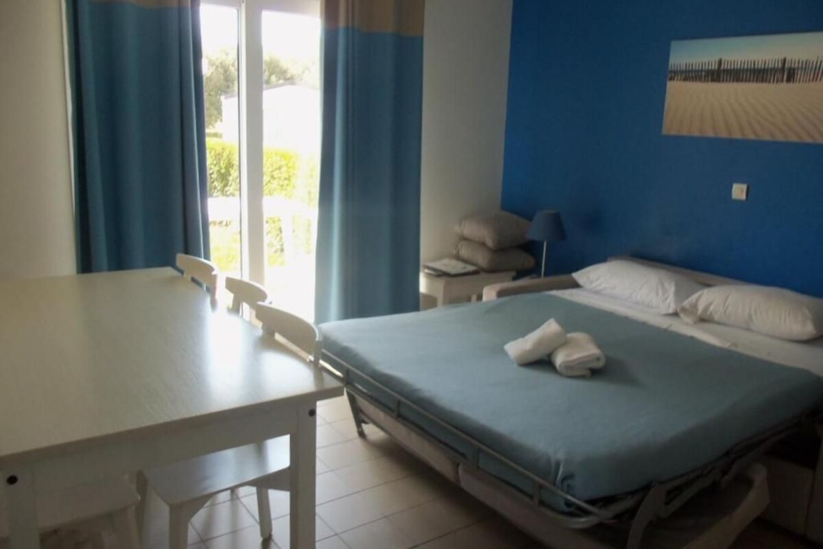 A room with a bed, a table, and a chair.