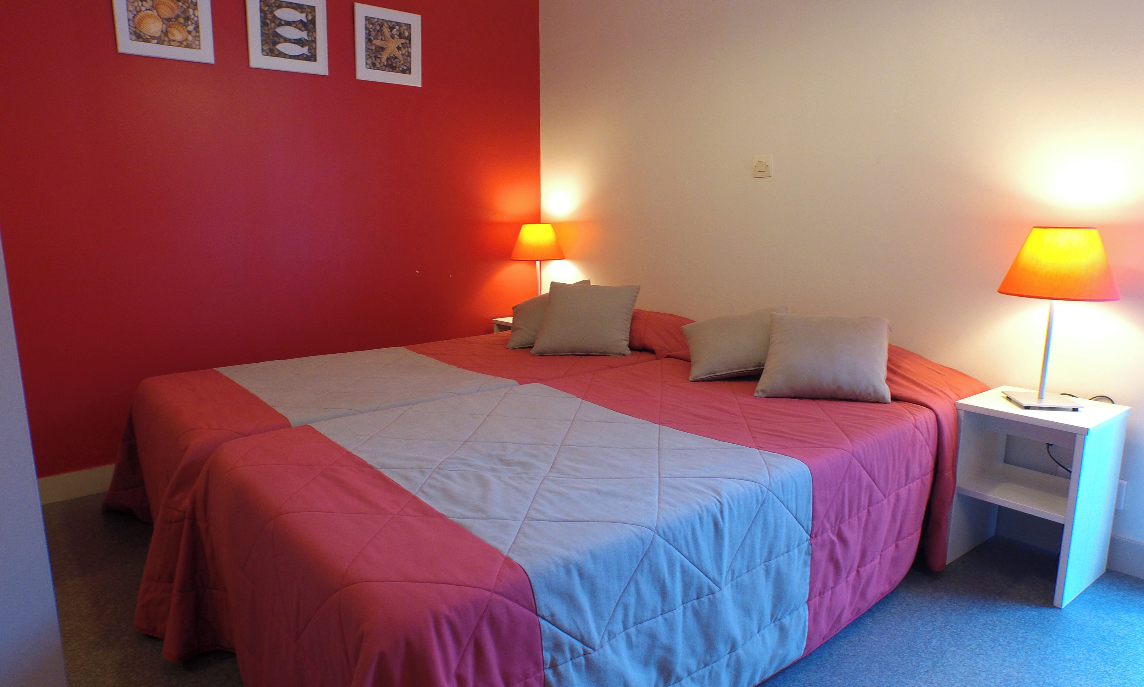 A bedroom with a bed, two bedside tables, and a nightstand.