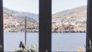 Cozinha com duas pias e vista para um lago e colinas.