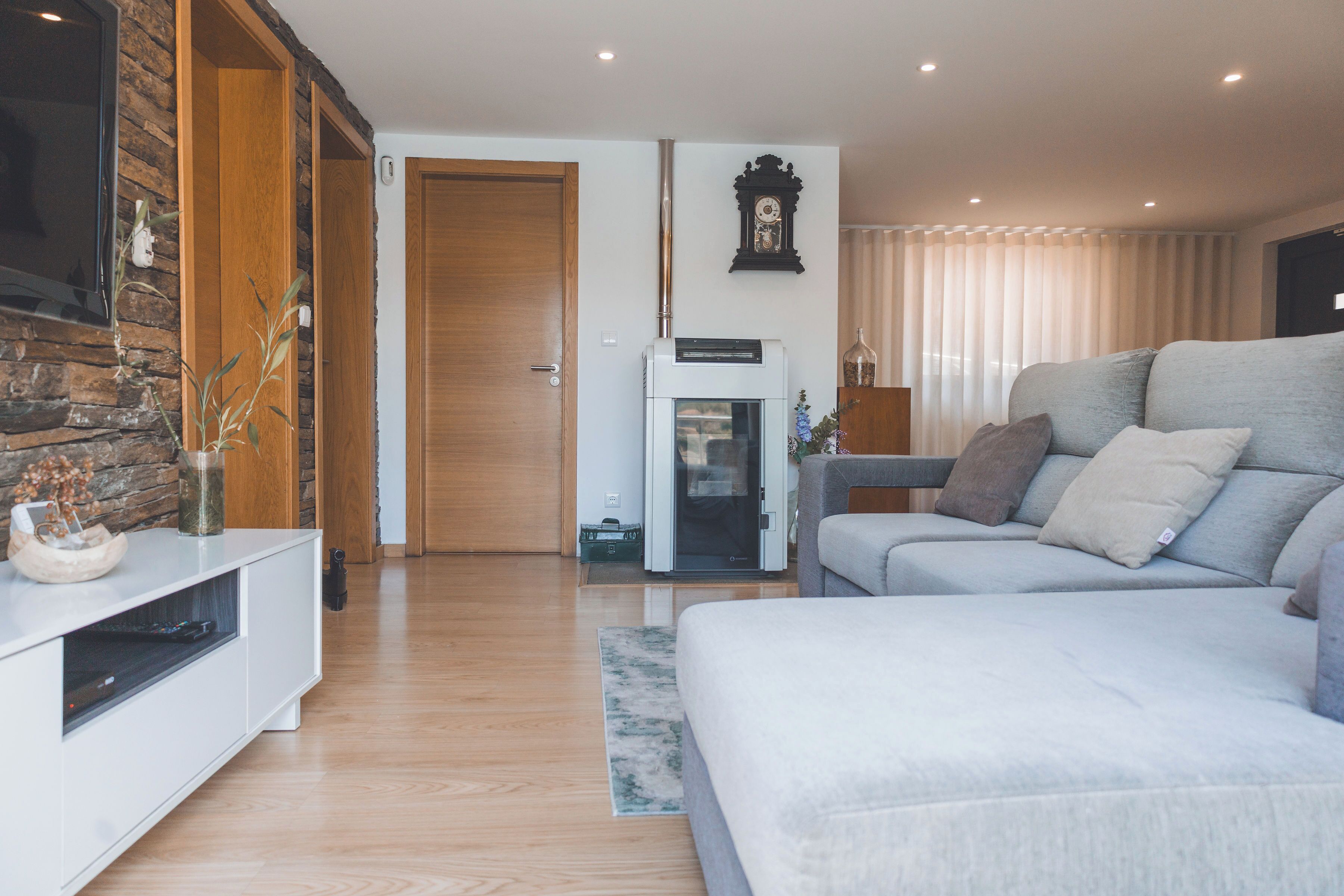 Una sala de estar moderna con un sofá, una chimenea y una pared de piedra.