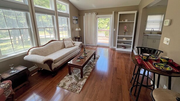 A spacious living room with a sofa, coffee table, and dining area. - Meadow Winds, A mountain getaway.  (Galax)
