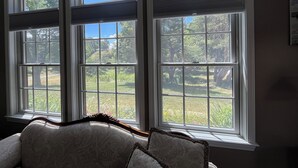A room with a large window overlooking a garden. - Meadow Winds, A mountain getaway.  (Galax)