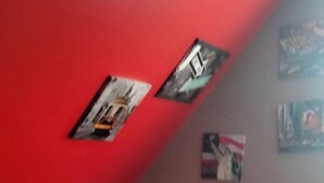 Un dormitorio con cama de madera, paredes rojas y techo inclinado.