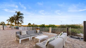 An outdoor patio area with a sofa set, a coffee table, and a railing. - 2BR/2BA Beach Condo: Gulf Views & Pools (Treasure Island)