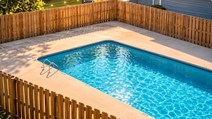 A rectangular swimming pool with a wooden deck surrounding it. - Suite Life Wilmington-Spacious, Pet-Friendly 1BR, Pool, Balcony, Prime Location (Wilmington)
