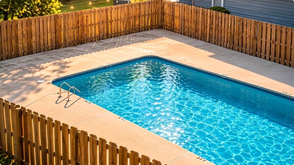 A rectangular swimming pool with a wooden deck surrounding it. - Suite Life Wilmington-Spacious, Pet-Friendly 1BR, Pool, Balcony, Prime Location (Wilmington)