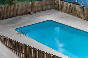 A rectangular swimming pool with a wooden fence surrounding it. - Suite Life Wilmington-Spacious, Pet-Friendly 1BR, Pool, Balcony, Prime Location (Wilmington)