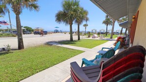 Ein Hotel direkt am Strand mit Außenbereich, Palmen und Blick auf den Strand.
