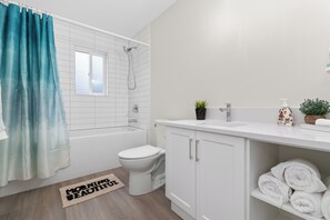 Een badkamer met een badkuip, toilet en wastafel.