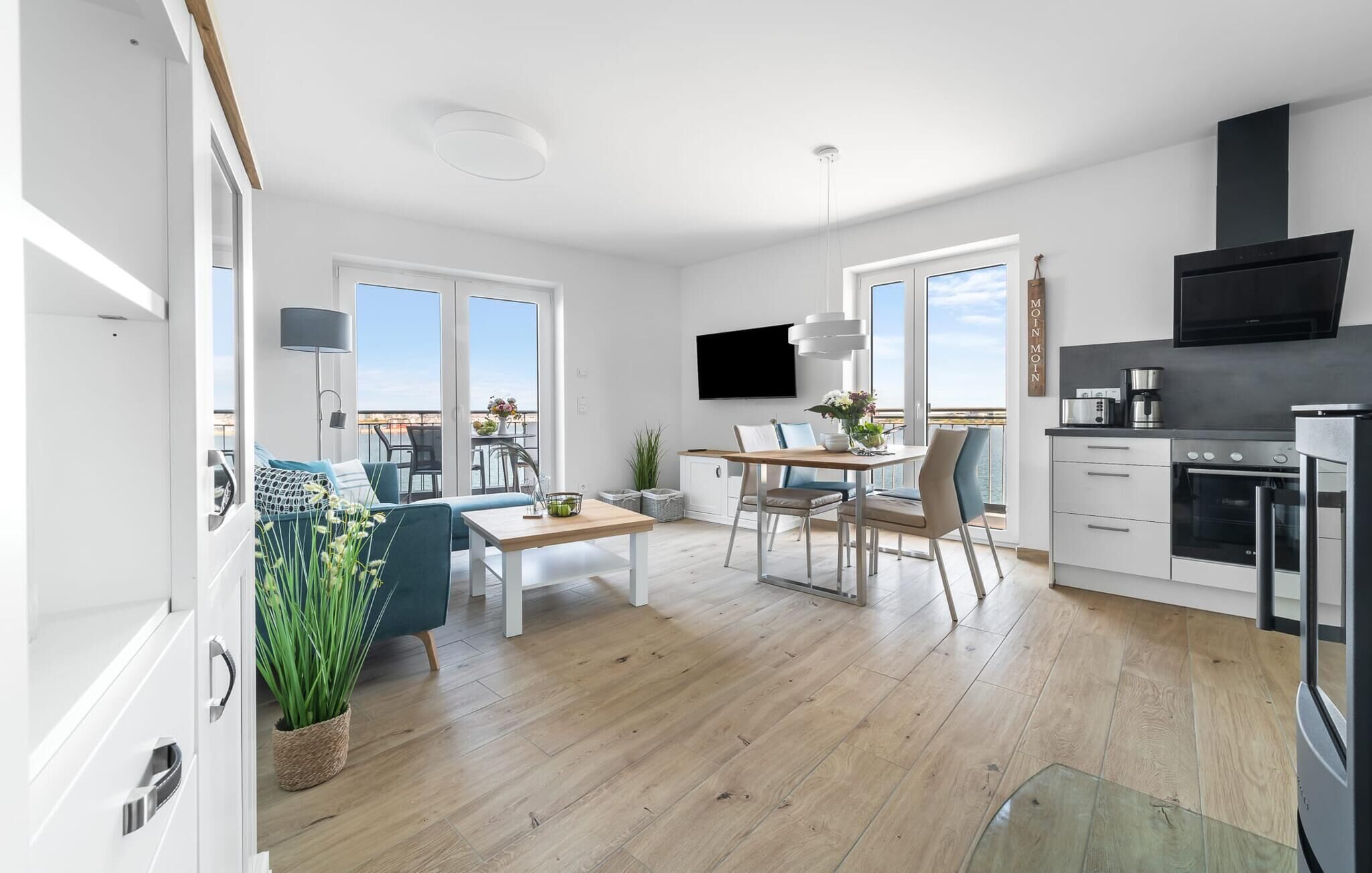 En moderne lejlighed med spiseplads, køkken og balkon med udsigt.