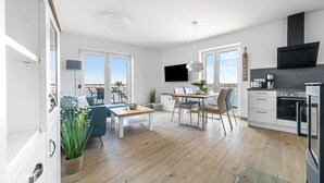 Eine moderne Wohnung mit Essbereich, Küche und einem Balkon mit Blick.
