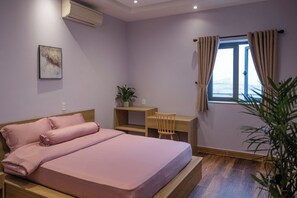 Une chambre à coucher avec un lit, un bureau et une fenêtre avec des rideaux.