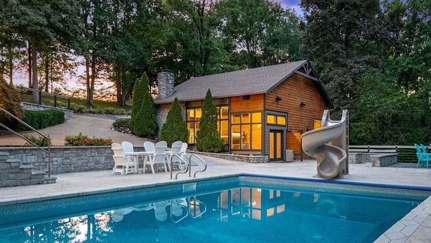 A swimming pool with a modern house in the background.