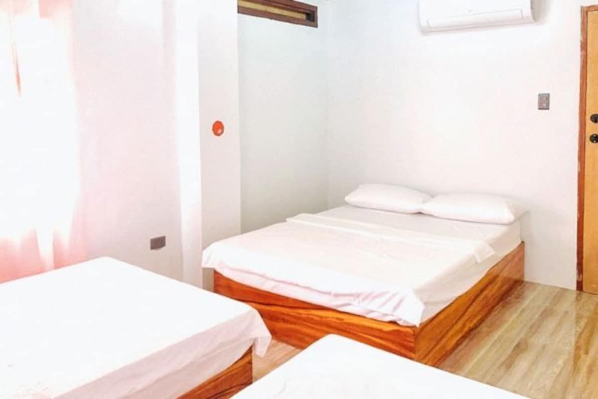 Una habitació amb un llit individual, un capçal de fusta i una taula petita.