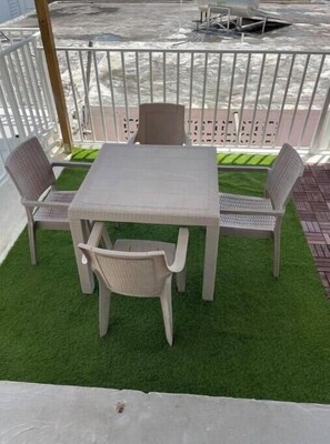 A patio area with a table and four chairs, surrounded by a white fence. - Instant House - Caguas (Caguas)