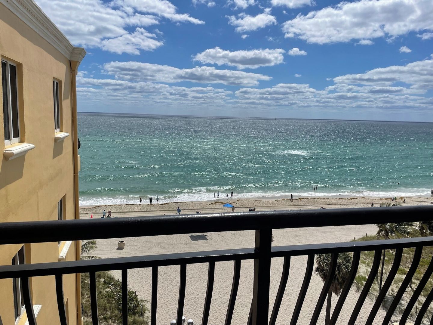A balcony with a view of the ocean and beach.