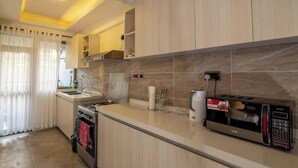 Una cocina moderna con horno integrado, microondas y cafetera.