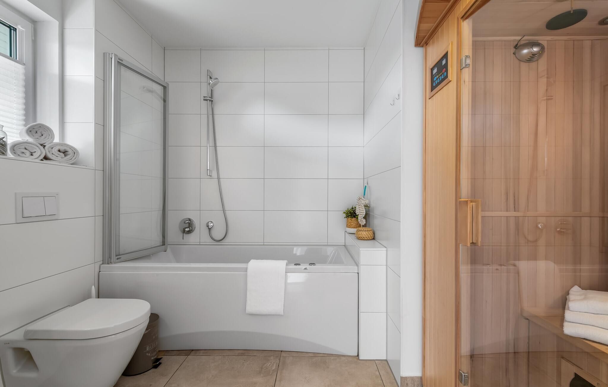 A modern bathroom with a shower, toilet, and bathtub.