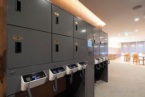 A row of lockers with a control panel and a seating area in the background. - Washington R&B Hotel Sendai Higashiguchi (Sendai)