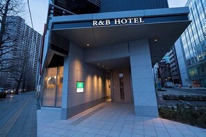 The R&B Hotel entrance with a modern facade, a visible entrance, and a green sign indicating amenities. - Washington R&B Hotel Sendai Higashiguchi (Sendai)