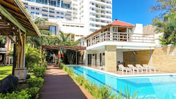 Alberca al aire libre, sombrillas en la alberca y camastros