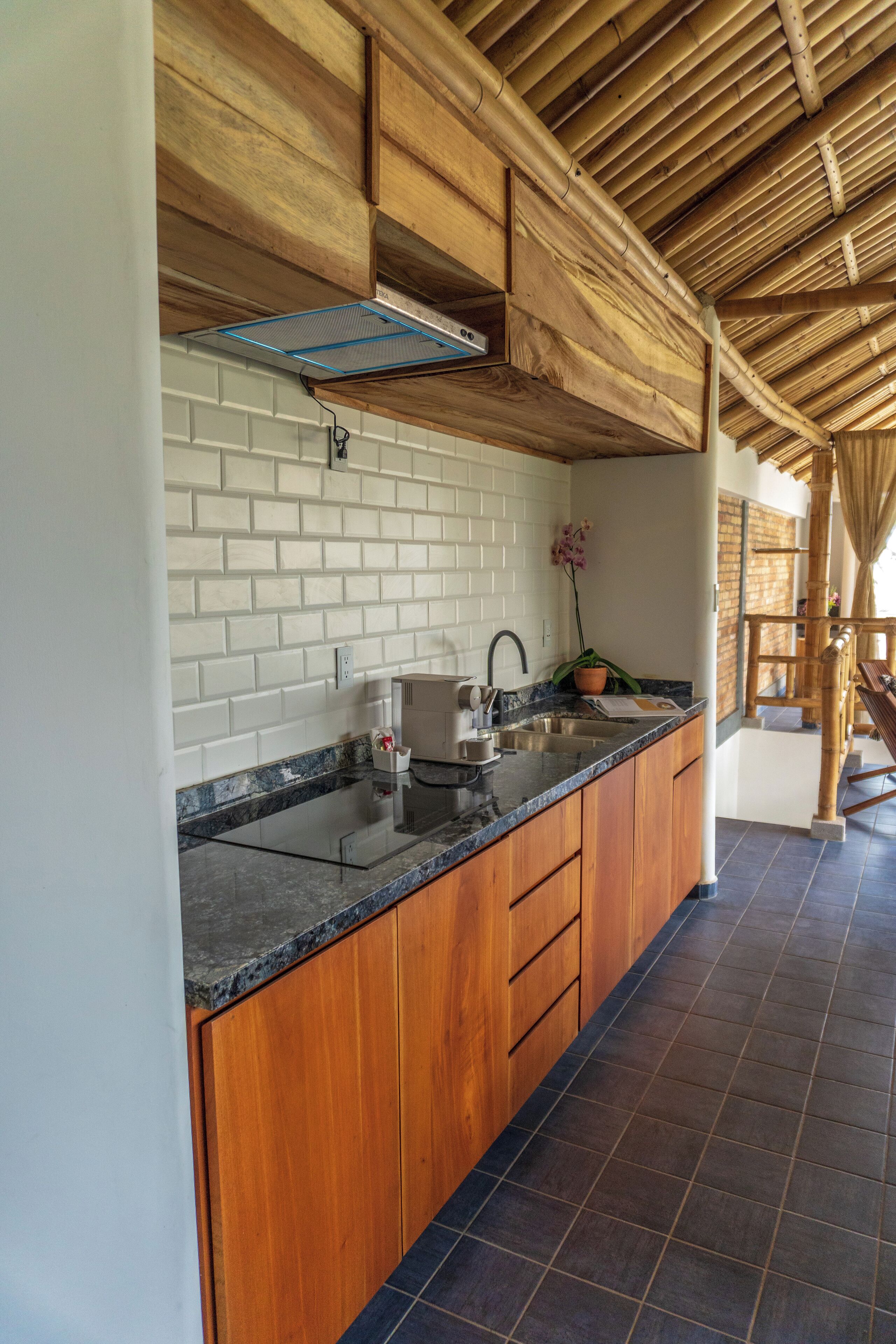 A kitchen with wooden cabinets, a black countertop, and a tiled backsplash.