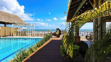 Una piscina al aire libre, sombrillas, sillones reclinables de piscina