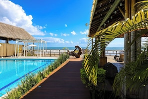 Alberca al aire libre, sombrillas en la alberca y camastros