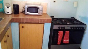 Una cocina equipada con microondas, tostadora y estufa a gas.