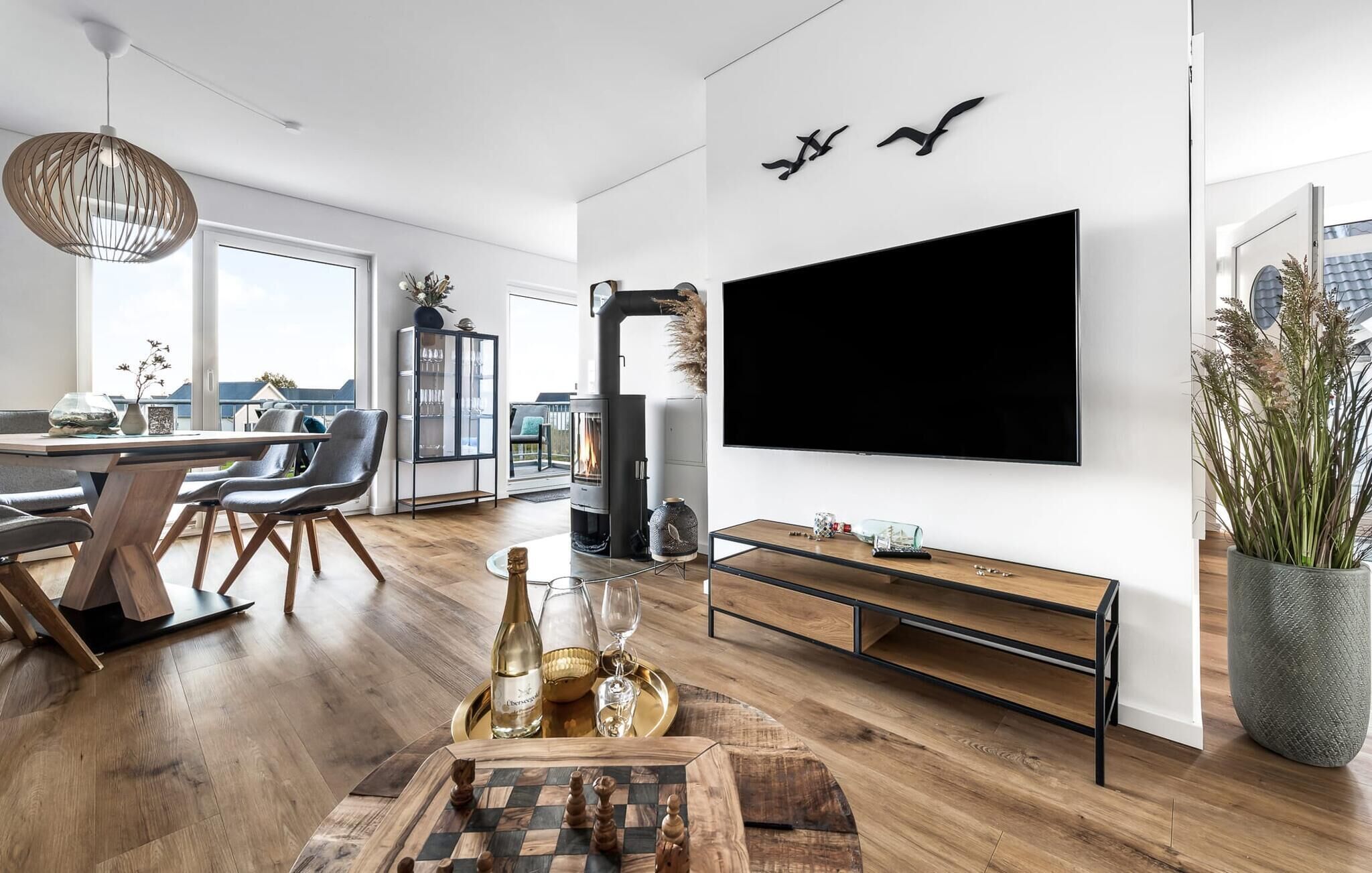 A modern living room with a large TV, wooden furniture, and a fireplace.