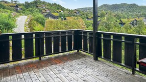 Una terraza de madera con vistas a un pueblo en la ladera.