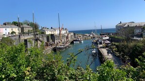 A coastal town with a harbor, boats, and buildings along the waterfront.