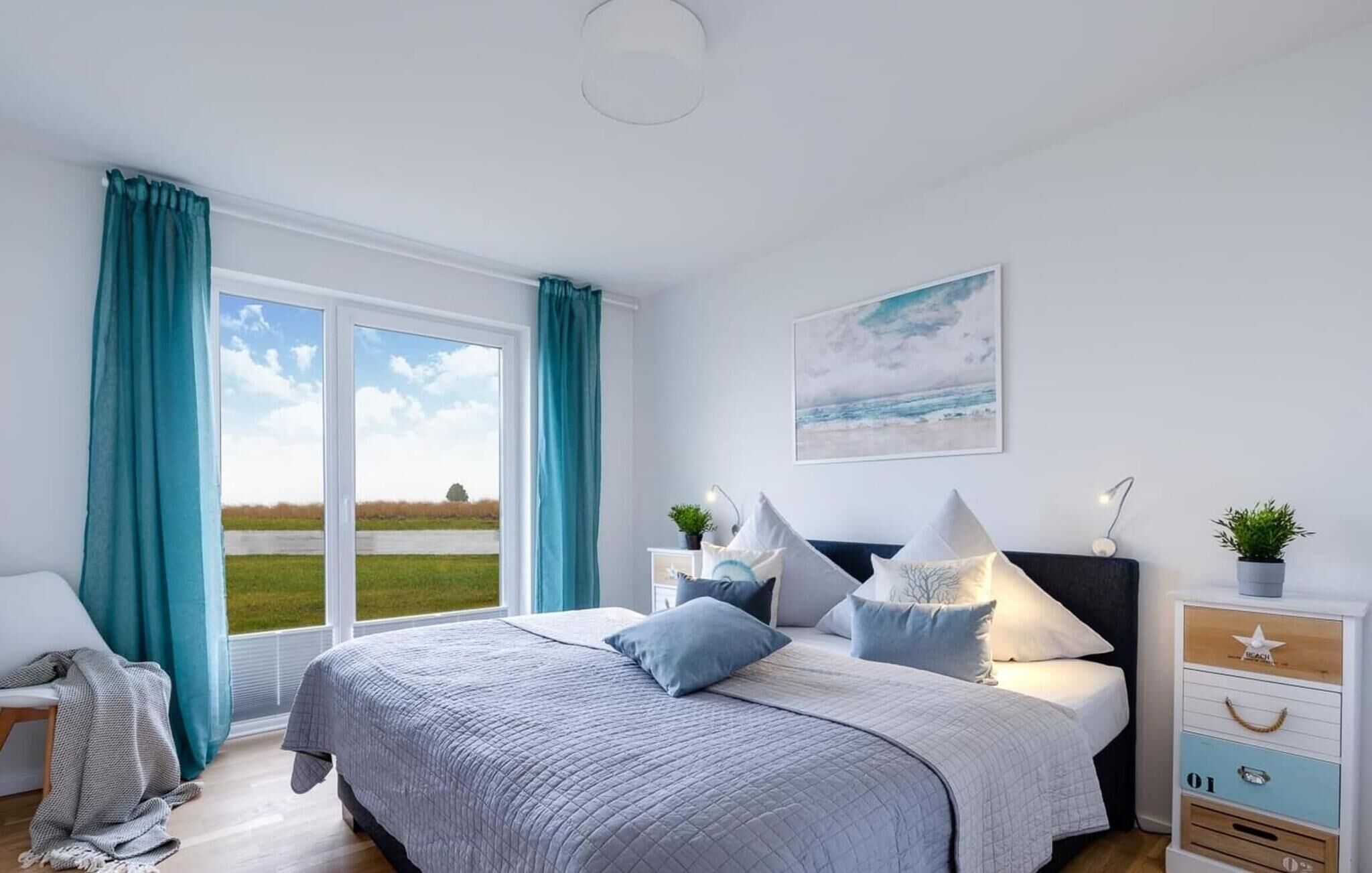 A bedroom with a large bed, a nightstand, a dresser, and a window with curtains.
