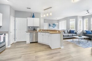 A modern kitchen with white cabinets, a wooden island, and a built-in dishwasher. - 2/2 Condo Minutes From Disney at Terrace Ridge at Town Center (Davenport)