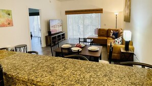 A living room with a dining area, a television, and a sofa. - Huge Screened Patio That Overlooks Lake Buck, Near Famous Attractions!! (Kissimmee)