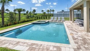 A rectangular swimming pool with a tiled deck, surrounded by palm trees and a clear sky. - Amazing 4/3 Home at Reunion!! With Private Pool, Near Disney and Universal!! (Kissimmee)