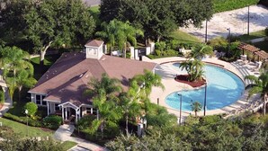 An aerial view of a residential property with a swimming pool, surrounded by lush greenery and a small house with a porch. - 4/3 Townhouse Near Disney!! (Kissimmee)