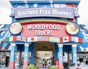 A colorful building with a sign reading "Visitors Flea Market" and "World Food Trucks".