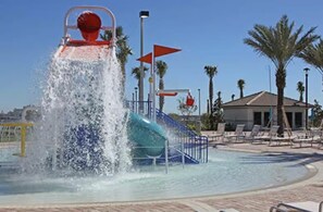 A water slide at a resort with palm trees and a building in the background. - Brand New Condo at Champion Gate With Golf View, Near Famous Attractions (Kissimmee)