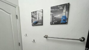 Une salle de bain avec une porte blanche, un porte-serviettes et un tapis à motifs sur le sol.