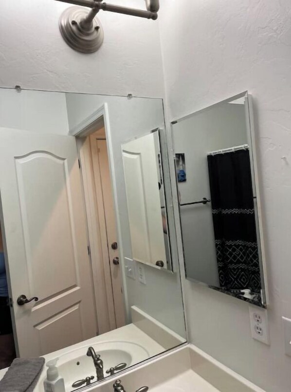 Une salle de bain avec un lavabo blanc, un miroir et un porte-serviettes.